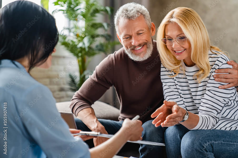 Irrational Risk YOLO Investing: Destroying Your Financial and Mental Health 13 Estate agent or financial adviser showing terms of contract to happy couple on notepad